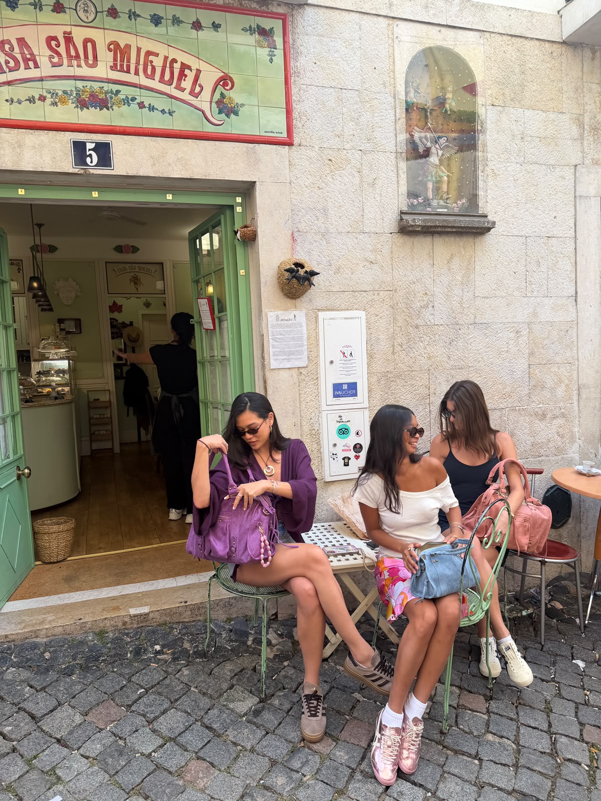 Drie vrouwen met FrancisbyFB tassen op een terras bij Casa São Miguel in Lissabon